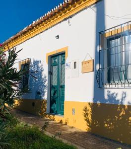 uma casa branca e amarela com uma porta verde em Às Portas da Vila em Monsaraz