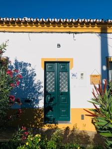 uma porta verde do lado de um edifício em Às Portas da Vila em Monsaraz