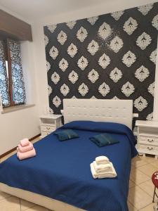 - une chambre avec un lit bleu et 2 serviettes dans l'établissement Casa Emily Verona, à Vérone