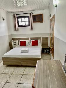 een slaapkamer met een groot bed met rode kussens bij Hotel City I in Santo André