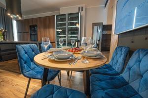 a table with chairs and wine glasses on it at Apartament w Cieplicach 7 Relax in Jelenia Góra