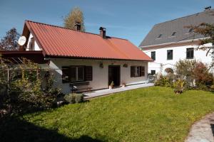 a white house with a red roof and a yard at Apartment "Johana" in Brod Moravice