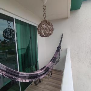 a hammock hanging from a wall in a room at Studio A completo 400m da praia in Porto De Galinhas