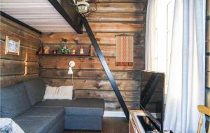 a living room with a couch in a room with wooden walls at 3 Bedroom Nice Home In Sjusjøen in Sjusjøen