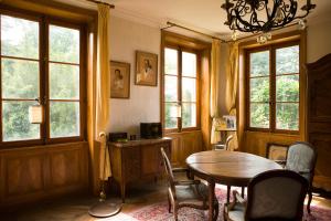 a dining room with a table and chairs and windows at Le Montellier in Blacé