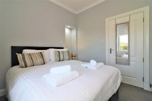 格拉斯哥的住宿－Signature - Greenlees Clubhouse，卧室配有带毛巾的大型白色床