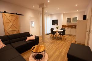 a living room with a black couch and a table at Urlaubsoase Moselglück in Kröv