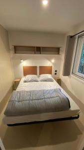 a bedroom with a large bed with a large window at Camping 3 étoiles Les Fougères in Rivedoux-Plage