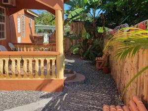 un patio trasero con una valla de madera y una escalera de madera en Mesmerize Guest House, en Port Antonio