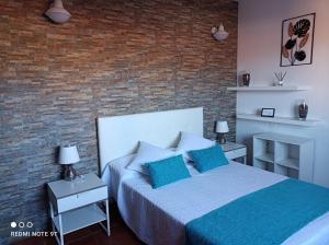 a bedroom with a bed and a brick wall at Ele House in Tarajalejo