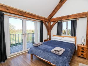 a bedroom with a bed and a balcony at Yr Adfa in Tregaron