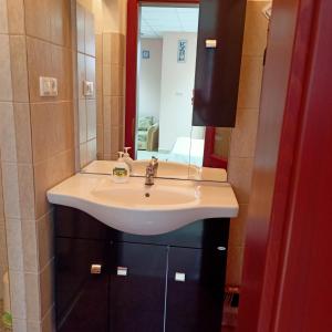 een badkamer met een wastafel en een spiegel bij Lívia Apartman in Bük