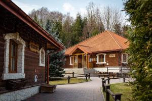 een paar houten gebouwen in een park bij Zajazd Przystocze - Bałtowski Kompleks Turystyczny in Bałtów