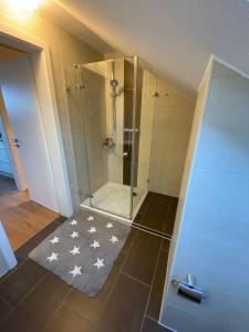 baño con ducha con alfombra de estrella en Ferienwohnung Brigitte en Goldkronach