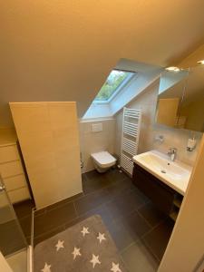 baño con aseo y lavabo y ventana en Ferienwohnung Brigitte en Goldkronach