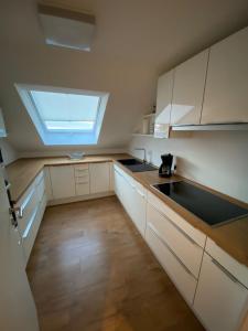 a kitchen with white cabinets and a skylight at Ferienwohnung Brigitte in Goldkronach