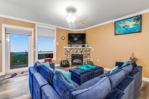 a living room with blue couches and a fireplace at Oceanfront Contemporary in Lincoln City