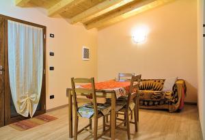 a dining room with a table and chairs and a couch at Agriturismo Il Melograno in Tessera