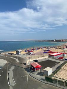 a view of a beach with a gas station and the ocean at Blue Whale Hurghada Beach Front Apartments City Centre in Hurghada