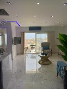 a living room with a television and a couch and a table at Blue Whale Hurghada Beach Front Apartments City Centre in Hurghada