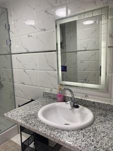 a bathroom counter with a sink and a mirror at Blue Whale Hurghada Beach Front Apartments City Centre in Hurghada