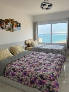 a bedroom with a bed with a view of the ocean at Blue Whale Hurghada Beach Front Apartments City Centre in Hurghada