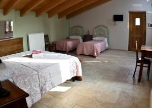 a bedroom with two beds and a table and chairs at b&b CASCINA SORTINA Country House in Ozzano Monferrato