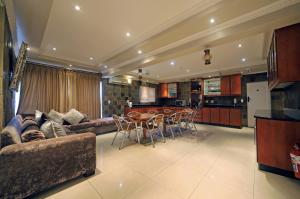 a living room with a couch and a table and chairs at Savoy Lodge in Cape Town