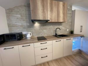 a kitchen with white cabinets and a sink and a microwave at Modern guest house in city center I Room 1 in Vilnius