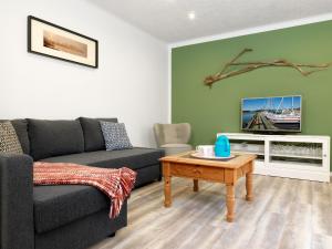 ein Wohnzimmer mit einem Sofa und einem Tisch in der Unterkunft Ferienanlage Poschmann Fischerstube in Insel Poel