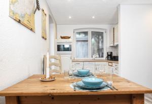 eine Küche mit einem Holztisch mit Tellern und Weingläsern in der Unterkunft Ferienanlage Poschmann Fischerstube in Insel Poel