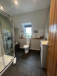 a bathroom with a toilet and a glass shower at Taigh Mara(Marine House) 2 bed Apartment in Fort William