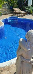 a statue of a mermaid sitting next to a swimming pool at Casa Tata in Tijarafe