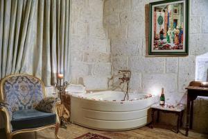 a bathroom with a bath tub and a chair at Mahperi Cappadocia Cave in Nevsehir +89 photos