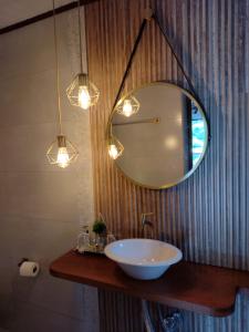 a bathroom with a sink and a mirror at Chale Disco de Arado in Visconde De Maua