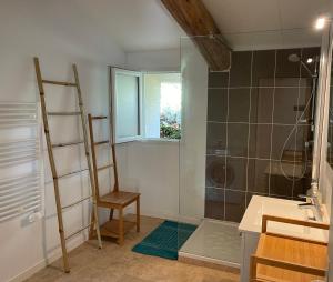 W łazience znajduje się prysznic, krzesło i umywalka. w obiekcie Pézenas Cottage avec terrasse et jardin 1 chambre et 1 mezzanine au coeur d'un domaine avec 2 piscines w mieście Alignan-du-Vent