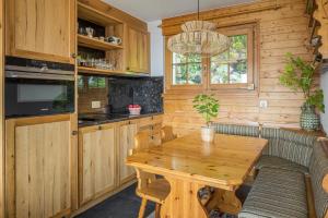 uma cozinha com uma mesa de madeira e uma sala de jantar em Am Bühl EG em Bettmeralp