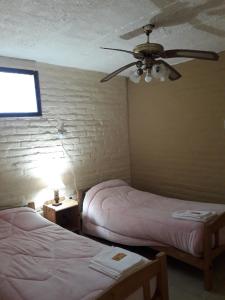 a bedroom with two beds and a ceiling fan at Finca ELSA in San Agustín de Valle Fértil
