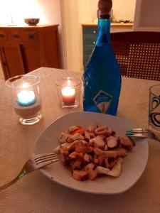 Cataldo Guest House في كابري: طبق من الطعام على طاولة مع زجاجة وشمعة