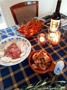 Cataldo Guest House في كابري: طاولة مليئة بأطباق الطعام وزجاجة من النبيذ