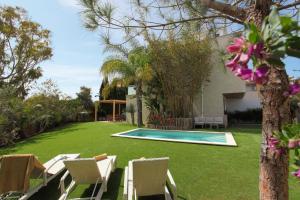 un cortile con piscina, sedie e una casa di VillaSpa a Alcudia