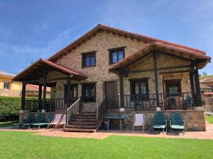 uma casa com um deque e cadeiras no quintal em Casa de turismo rural San Martín de valdetuejar em San Martín de Valdetuéjar