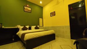 a bedroom with a bed with a green wall at Ranthambore Aravalli in Sawāi Mādhopur