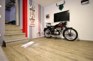 a motorcycle parked in a room with a flat screen tv at Il Turista a Pedali in Ceva