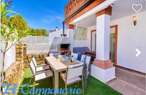 a patio with a table and chairs and a fireplace at Casa El Campanario in El Bosque