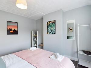威根的住宿－Stunning Family Home with Comfortable Surroundings，一间卧室配有一张带粉色毯子的床