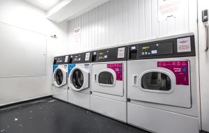 a row of washing machines in a laundry room at Theatre House Apartment 13 in Coventry