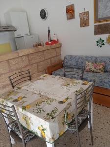 een tafel en stoelen met een tafelkleed erop bij E case tu Bertu in Marina di Mancaversa