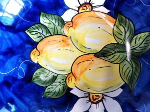 a painting of four lemons on a blue background at Casa Villani in Agerola