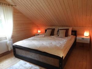 een slaapkamer met een groot bed op zolder bij Domek Mazury całoroczny letniskowy Dom Apartament na Mazurach in Ryn